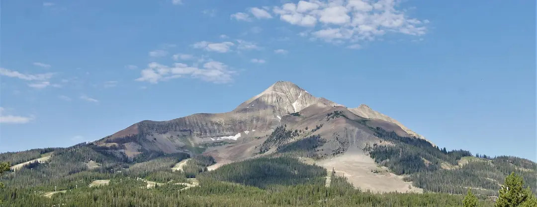 Lone Mountain rising above forested slopes near Big Sky, Montana, under a blue summer sky